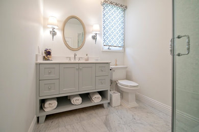 Réalisation d'une petite salle d'eau tradition avec un placard à porte shaker, des portes de placard blanches, un carrelage blanc, un plan de toilette en surface solide, une douche d'angle, WC séparés, du carrelage en marbre, un mur blanc, un sol en marbre et un lavabo encastré.