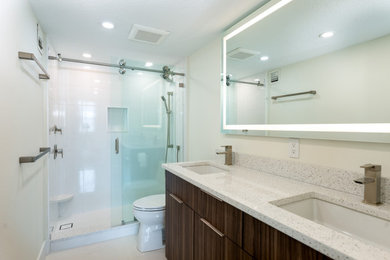 Modernes Badezimmer mit braunen Schränken, weißen Fliesen, Porzellanfliesen, Porzellan-Bodenfliesen, Unterbauwaschbecken, Quarzit-Waschtisch, weißer Waschtischplatte und Doppelwaschbecken in Tampa