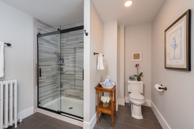 Medium sized classic ensuite bathroom in Other with shaker cabinets, dark wood cabinets, an alcove shower, a two-piece toilet, grey tiles, porcelain tiles, grey walls, porcelain flooring, a submerged sink, quartz worktops, grey floors, a sliding door and white worktops.