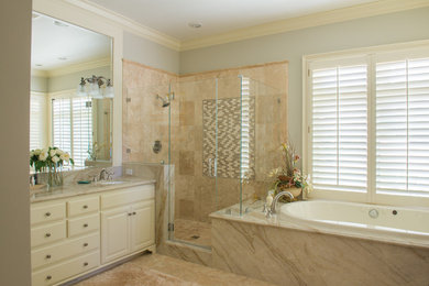 Bathroom - mid-sized traditional master beige tile and ceramic tile ceramic tile and beige floor bathroom idea in San Francisco with raised-panel cabinets, white cabinets, gray walls, an undermount sink, granite countertops, a hinged shower door and beige countertops