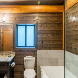 Bathroom - mid-sized rustic 3/4 gray tile and ceramic tile ceramic tile, gray floor, single-sink, shiplap ceiling and shiplap wall bathroom idea in Vancouver with shaker cabinets, dark wood cabinets, a two-piece toilet, gray walls, an undermount sink, granite countertops, a hinged shower door, gray countertops and a built-in vanity