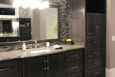 Inspiration for a large transitional master ceramic tile doorless shower remodel in Minneapolis with gray walls, an undermount sink, recessed-panel cabinets, dark wood cabinets, an undermount tub and granite countertops