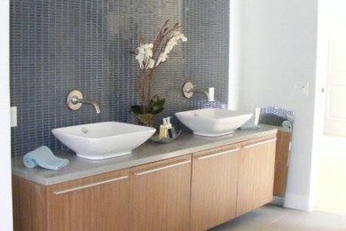 Ispirazione per una grande stanza da bagno minimal con ante lisce, ante in legno chiaro, piastrelle grigie, pareti bianche e lavabo a bacinella