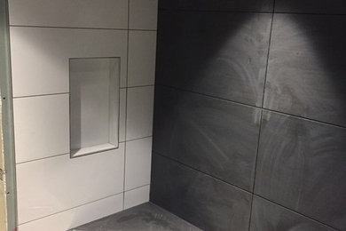 Diseño de cuarto de baño moderno de tamaño medio con baldosas y/o azulejos negros, aseo y ducha, ducha abierta y ducha esquinera