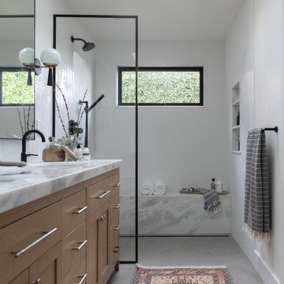 Inspiration for a large transitional 3/4 white tile and porcelain tile limestone floor, gray floor, double-sink and vaulted ceiling bathroom remodel in San Francisco with recessed-panel cabinets, light wood cabinets, a bidet, white walls, an undermount sink, marble countertops, a hinged shower door, white countertops and a built-in vanity