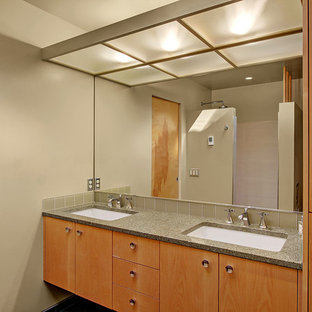 Foto di una stanza da bagno padronale moderna di medie dimensioni con ante lisce, ante in legno chiaro, doccia aperta, piastrelle verdi, piastrelle di vetro, pareti verdi, pavimento in gres porcellanato, lavabo sottopiano e top in vetro riciclato