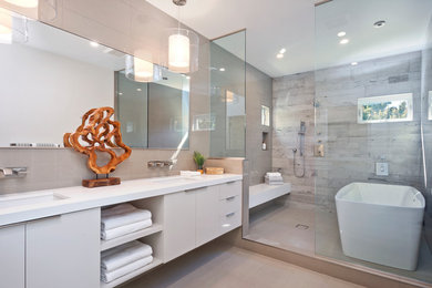ロサンゼルスにあるコンテンポラリースタイルのおしゃれなマスターバスルーム (フラットパネル扉のキャビネット、グレーのキャビネット、置き型浴槽、洗い場付きシャワー、グレーのタイル、アンダーカウンター洗面器、グレーの床、白い洗面カウンター) の写真