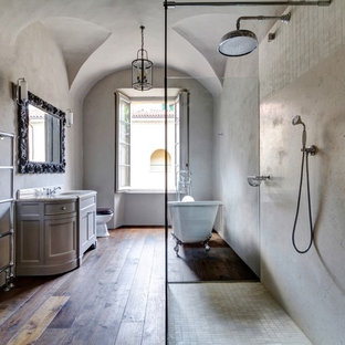 Example of a large tuscan dark wood floor bathroom design in London with multicolored walls and a drop-in sink