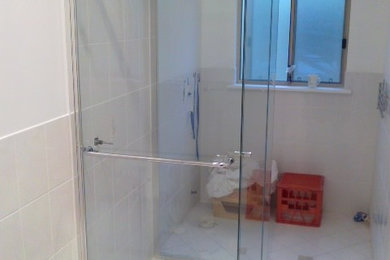 Пример оригинального дизайна: ванная комната в стиле модернизм с душем в нише и плиткой из листового стекла