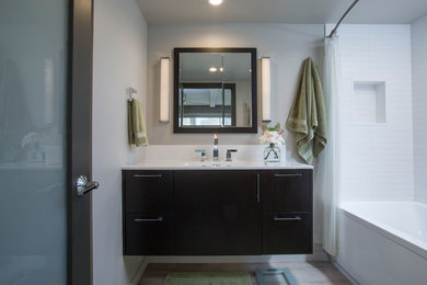 Example of a mid-sized transitional master white tile and porcelain tile porcelain tile alcove bathtub design in Hawaii with flat-panel cabinets, dark wood cabinets, a two-piece toilet, gray walls and an integrated sink