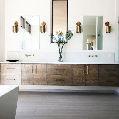 Example of a large trendy master porcelain tile and white floor bathroom design in Santa Barbara with flat-panel cabinets, medium tone wood cabinets, a one-piece toilet, white walls, an undermount sink, quartz countertops, a hinged shower door and white countertops
