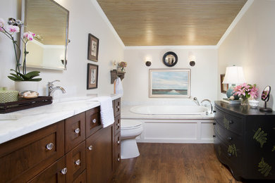 Пример оригинального дизайна: ванная комната в классическом стиле с фасадами в стиле шейкер, темными деревянными фасадами, мраморной столешницей и накладной ванной