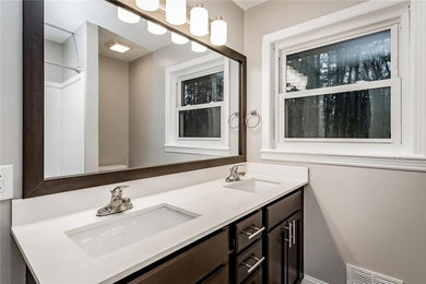 Photo of a medium sized modern ensuite bathroom in Atlanta with raised-panel cabinets, dark wood cabinets, an alcove bath, a two-piece toilet, grey walls, a submerged sink, laminate worktops, a shower curtain and white worktops.