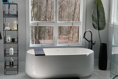 Diseño de cuarto de baño principal contemporáneo de tamaño medio con bañera exenta, ducha esquinera, paredes grises, suelo de mármol, suelo blanco y ducha con puerta con bisagras