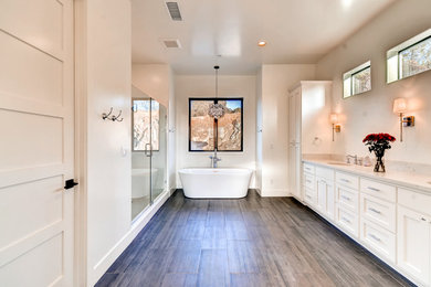 Example of a large classic master dark wood floor and brown floor bathroom design in Sacramento with shaker cabinets, white cabinets, beige walls, an undermount sink, marble countertops, a hinged shower door and gray countertops