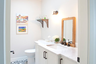 Bathroom - mid-sized transitional white tile and ceramic tile ceramic tile and black floor bathroom idea in Vancouver with shaker cabinets, white cabinets, a two-piece toilet, gray walls, an undermount sink, quartz countertops and white countertops