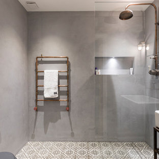 Immagine di una stanza da bagno per bambini industriale di medie dimensioni con doccia aperta, piastrelle di vetro, pareti grigie, pavimento in cementine e lavabo a bacinella