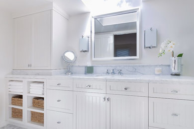 Mid-sized beach style master white tile and stone tile mosaic tile floor bathroom photo in Santa Barbara with an undermount sink, beaded inset cabinets, white cabinets, marble countertops, a one-piece toilet and white walls