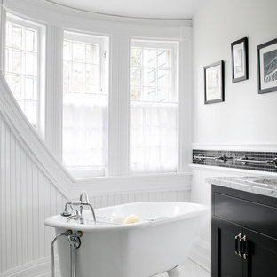 Claw-foot bathtub - victorian black and white tile claw-foot bathtub idea in Boston with shaker cabinets, black cabinets and white walls