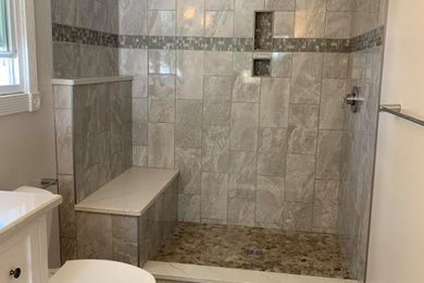 Example of a mid-sized trendy master glass tile porcelain tile and single-sink bathroom design in Bridgeport with a two-piece toilet and solid surface countertops