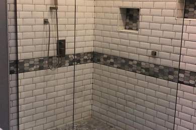 Example of a trendy white tile and subway tile corner shower design in Houston with a hinged shower door