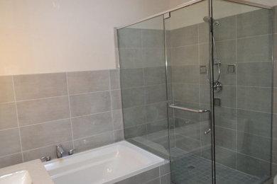 Idéer för att renovera ett mellanstort vintage en-suite badrum, med ett platsbyggt badkar, en dusch i en alkov, en toalettstol med hel cisternkåpa, grå kakel, porslinskakel, grå väggar, ett undermonterad handfat och dusch med gångjärnsdörr
