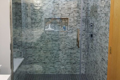 Aménagement d'une petite salle de bain contemporaine en bois foncé avec un placard à porte shaker, WC à poser, un carrelage gris, un carrelage en pâte de verre, un mur blanc, un lavabo encastré, un plan de toilette en quartz modifié, un sol gris, une cabine de douche à porte coulissante et un plan de toilette blanc.