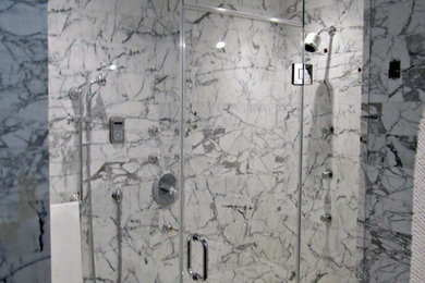 Klassisches Badezimmer mit Duschnische, grauen Fliesen, Marmorfliesen und Falttür-Duschabtrennung in New York