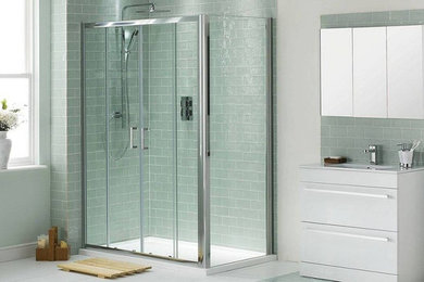 Example of a mid-sized trendy master gray tile and porcelain tile porcelain tile and white floor corner shower design in Other with flat-panel cabinets, white cabinets, gray walls, an integrated sink, solid surface countertops, a hinged shower door and white countertops