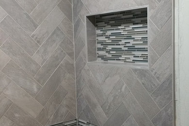 Diseño de cuarto de baño principal actual de tamaño medio con azulejos en listel, combinación de ducha y bañera, baldosas y/o azulejos negros, baldosas y/o azulejos blancas y negros, baldosas y/o azulejos grises y paredes grises