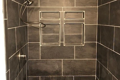 シャーロットにある中くらいなトランジショナルスタイルのおしゃれなバスルーム (浴槽なし) (アルコーブ型シャワー、黒いタイル、スレートタイル、玉石タイル、グレーの床、黒い壁、開き戸のシャワー) の写真