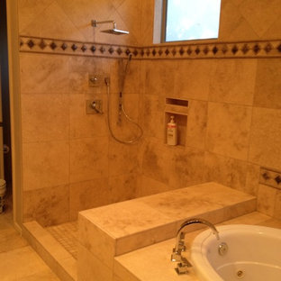 This is an example of a large traditional master bathroom in Phoenix with recessed-panel cabinets, dark wood cabinets, a drop-in tub, a corner shower, beige tile, brown tile, stone tile, beige walls, travertine floors, an undermount sink and granite benchtops.