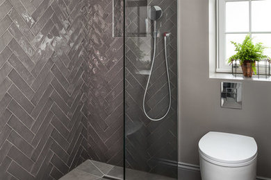 Réalisation d'une salle de bain design de taille moyenne avec une douche ouverte, WC à poser, un carrelage gris, des carreaux de céramique, un mur gris, un sol en carrelage de porcelaine, un sol gris et une cabine de douche à porte battante.