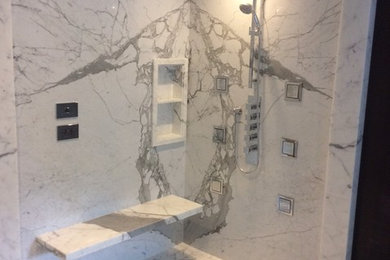 Shower with lights in wall behind marble panels