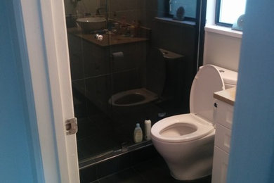 Example of a small trendy 3/4 corner shower design in Vancouver with recessed-panel cabinets, white cabinets, a one-piece toilet, a vessel sink and solid surface countertops
