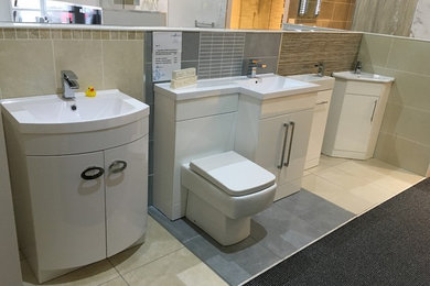 Photo of a bathroom in Glasgow with white cabinets, a one-piece toilet, grey tiles, ceramic tiles, porcelain flooring and grey floors.