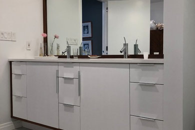 Mittelgroßes Modernes Badezimmer En Suite mit flächenbündigen Schrankfronten, weißen Schränken, Duschnische, weißen Fliesen, Porzellanfliesen, Quarzwerkstein-Waschtisch, Falttür-Duschabtrennung und weißer Waschtischplatte in Baltimore