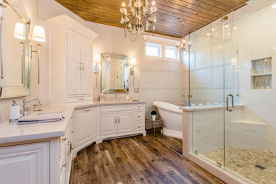 Example of a classic master medium tone wood floor and brown floor bathroom design in Houston with raised-panel cabinets, white cabinets, white walls, an undermount sink and gray countertops