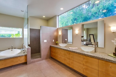 Großes Modernes Badezimmer En Suite mit flächenbündigen Schrankfronten, Einbaubadewanne, Eckdusche, Porzellanfliesen, Aufsatzwaschbecken, Granit-Waschbecken/Waschtisch, beiger Wandfarbe, Porzellan-Bodenfliesen und beigem Boden in San Diego