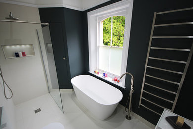 Design ideas for a medium sized contemporary family bathroom in Surrey with a freestanding bath, a walk-in shower, a wall mounted toilet, white tiles, porcelain tiles, blue walls, porcelain flooring, a wall-mounted sink and white floors.