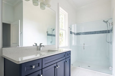 Mid-sized trendy kids' porcelain tile and white floor walk-in shower photo in Raleigh with flat-panel cabinets, blue cabinets, white walls, an undermount sink, quartz countertops, a hinged shower door and white countertops