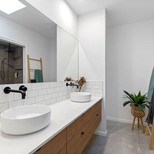 This is an example of a large contemporary 3/4 bathroom in Sunshine Coast with flat-panel cabinets, medium wood cabinets, white tile, subway tile, white walls, a vessel sink, grey floor, white benchtops, a double vanity and a floating vanity.