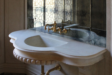 Diseño de cuarto de baño mediterráneo con paredes blancas, aseo y ducha, lavabo integrado y encimera de piedra caliza