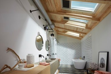 Photo of a contemporary bathroom in New York with flat-panel cabinets, light wood cabinets, a freestanding bath, a double shower, white tiles, metro tiles, white walls, painted wood flooring, an integrated sink, wooden worktops, white floors, an open shower and brown worktops.