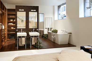 Inspiration for a large contemporary ensuite bathroom in San Francisco with a freestanding bath, brown tiles, ceramic tiles, beige walls, dark hardwood flooring and a pedestal sink.