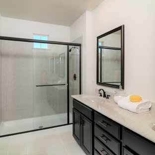 Example of a mid-sized trendy master porcelain tile and white floor bathroom design in Sacramento with recessed-panel cabinets, dark wood cabinets, a two-piece toilet, gray walls, an integrated sink and quartz countertops