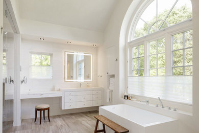 サンフランシスコにあるトランジショナルスタイルのおしゃれなマスターバスルーム (フラットパネル扉のキャビネット、白いキャビネット、置き型浴槽、白い壁、ベージュの床) の写真