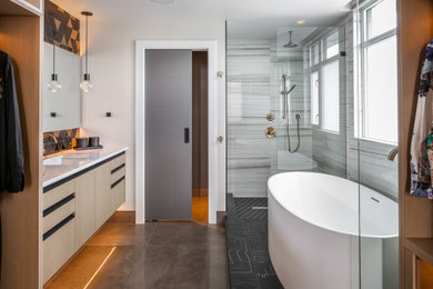 This is an example of a medium sized contemporary ensuite bathroom in Vancouver with flat-panel cabinets, light wood cabinets, a freestanding bath, a corner shower, multi-coloured tiles, white walls, concrete flooring, a submerged sink, quartz worktops, grey floors, an open shower and turquoise worktops.