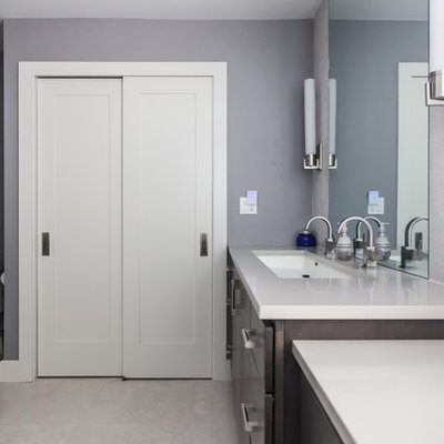 Example of a large transitional master gray tile and cement tile ceramic tile corner shower design in New York with flat-panel cabinets, dark wood cabinets, a two-piece toilet, blue walls, a trough sink and quartz countertops