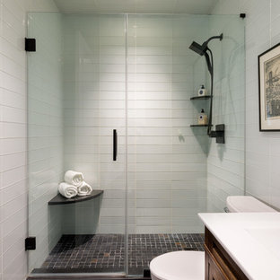 Modelo de cuarto de baño principal, bohemio, pequeño, con armarios con paneles con relieve, puertas de armario de madera oscura, ducha doble, sanitario de dos piezas, baldosas y/o azulejos blancos, baldosas y/o azulejos de vidrio, paredes blancas, suelo de baldosas de porcelana, lavabo integrado y encimera de cuarcita